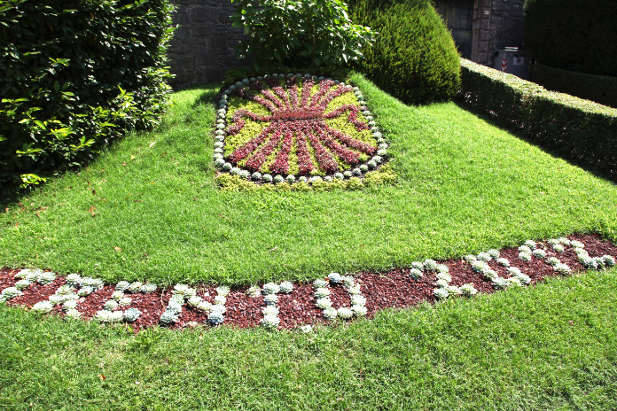 Trento sign in flowers and grass